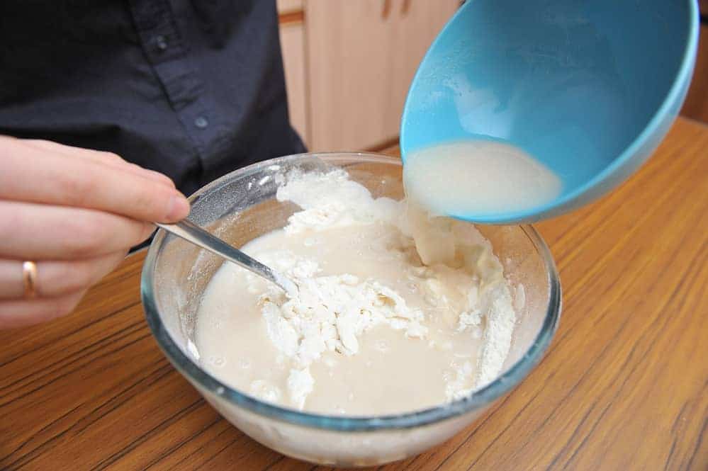 adding activated yeast to flour