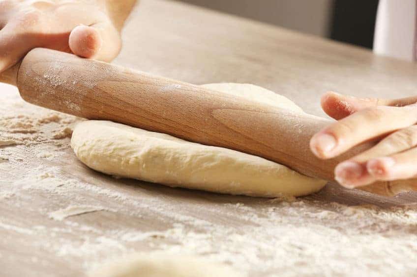 shaping pizza dough with rolling pin