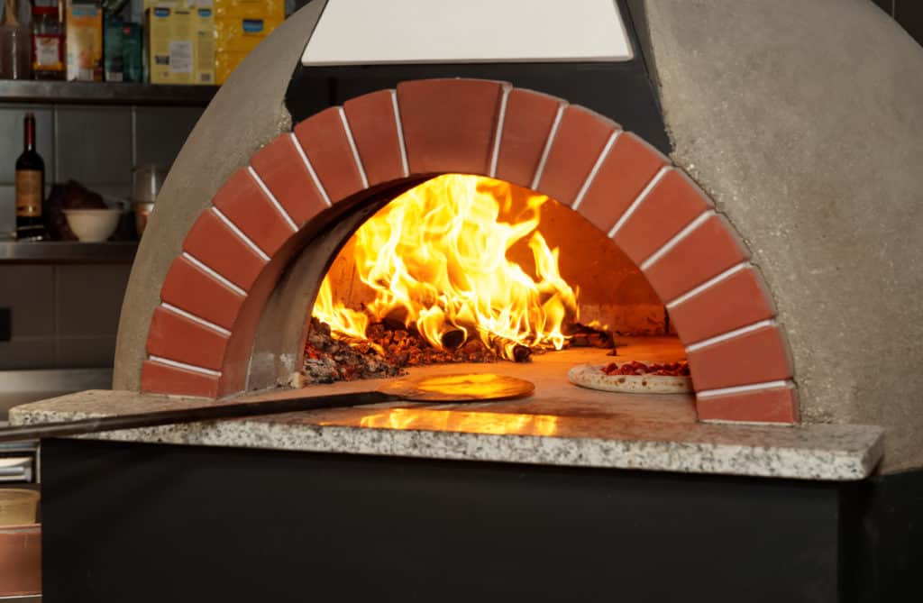 cooking pizza in wood fired oven