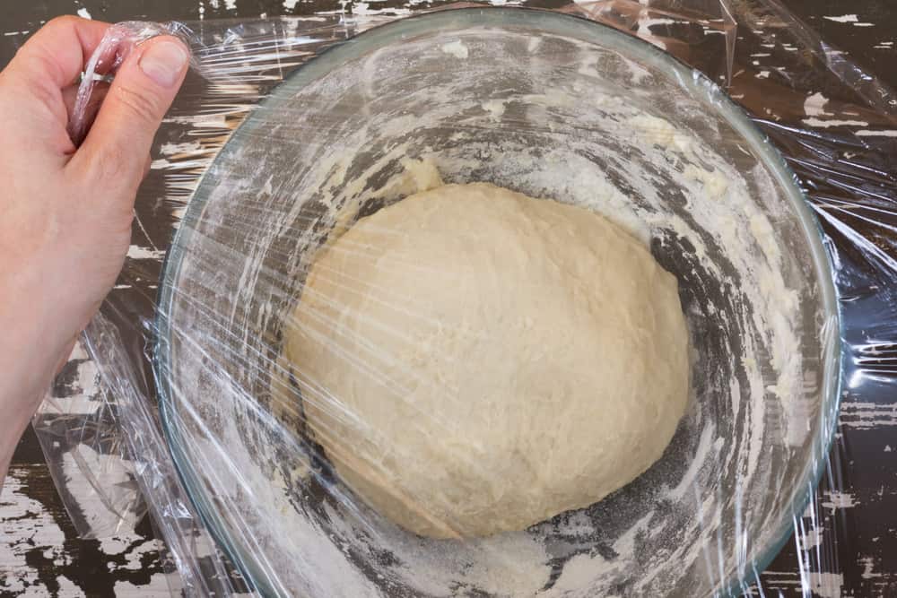 Cover dough in glass bowl using cling film