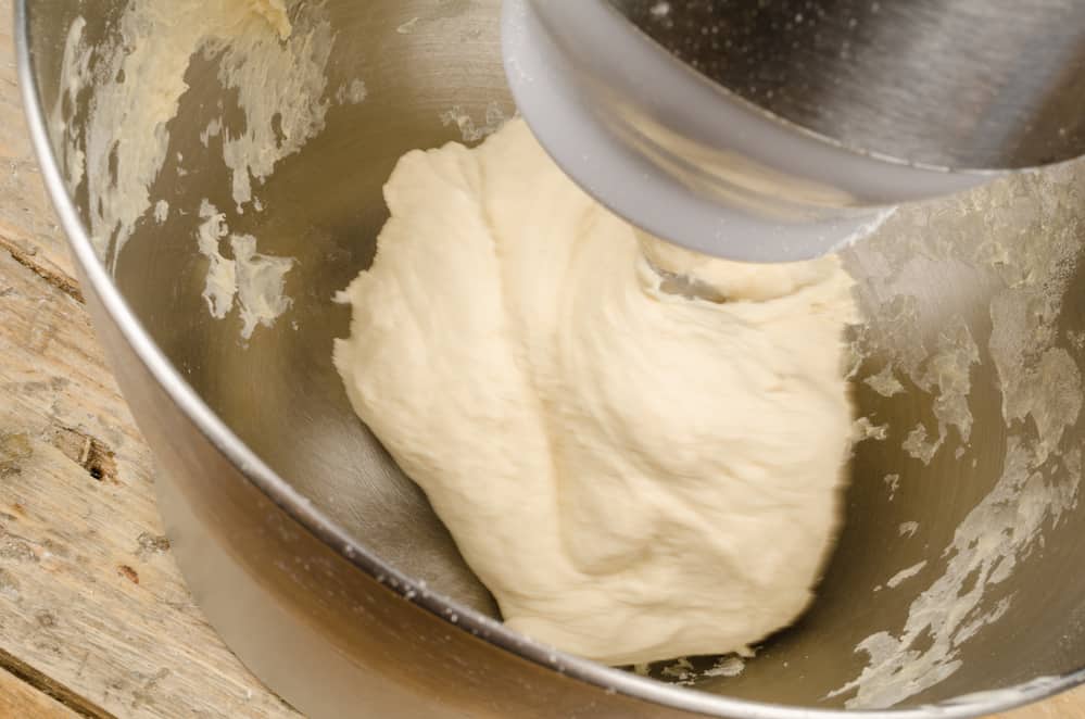 Kneading pizza dough in bowl
