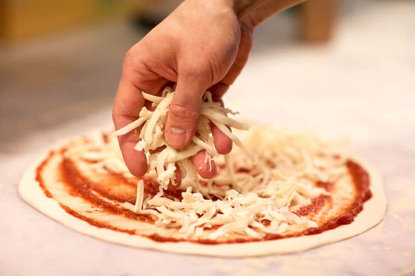 topping pizza with cheese