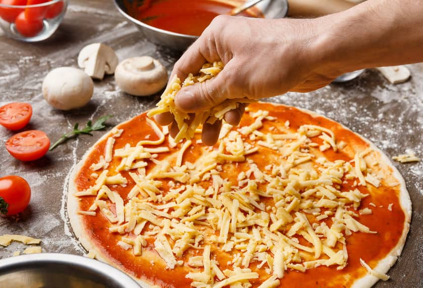 Adding cheese on pizza base