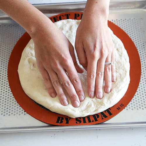 Placing pizza dough on Silpat